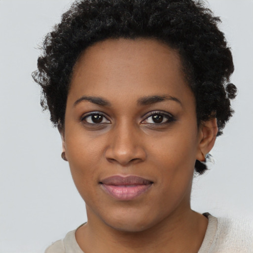 Joyful black young-adult female with short  black hair and brown eyes