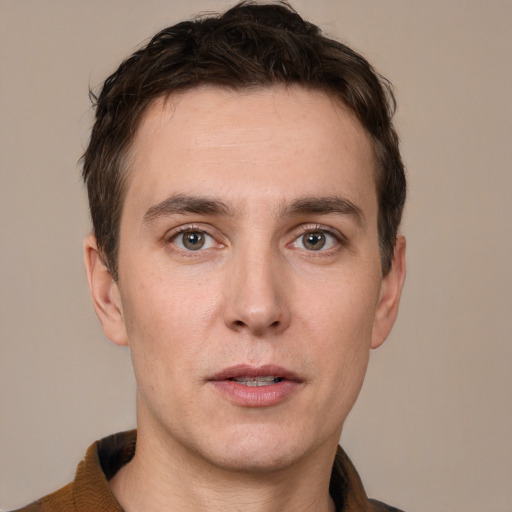 Joyful white young-adult male with short  brown hair and grey eyes