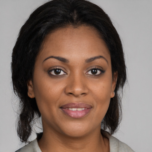 Joyful black young-adult female with medium  brown hair and brown eyes