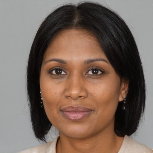 Joyful black adult female with medium  brown hair and brown eyes