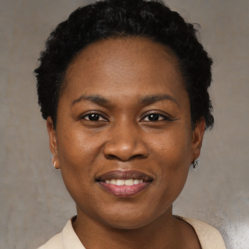 Joyful black young-adult female with short  black hair and brown eyes