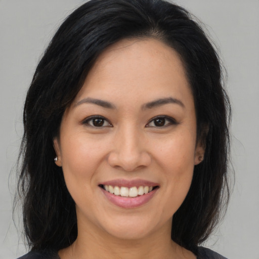 Joyful asian young-adult female with long  brown hair and brown eyes