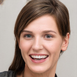 Joyful white young-adult female with medium  brown hair and grey eyes