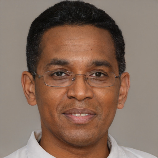 Joyful black adult male with short  brown hair and brown eyes
