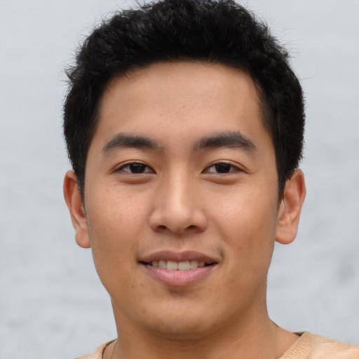 Joyful asian young-adult male with short  brown hair and brown eyes