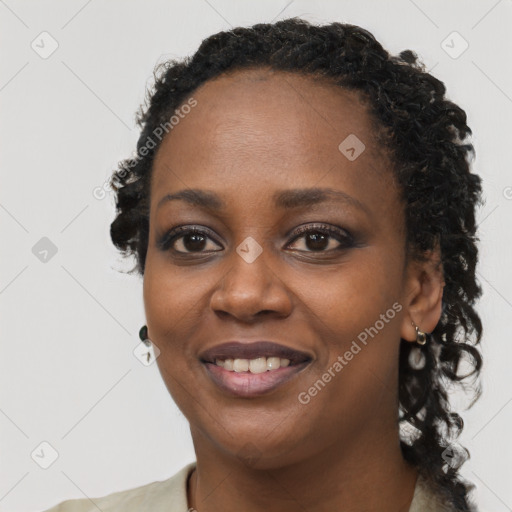 Joyful black young-adult female with long  black hair and brown eyes