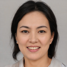 Joyful asian young-adult female with medium  brown hair and brown eyes