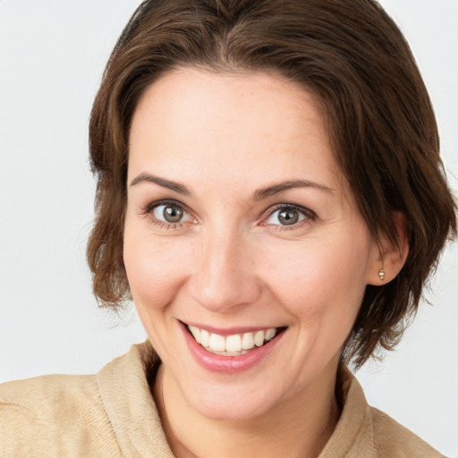 Joyful white young-adult female with medium  brown hair and grey eyes