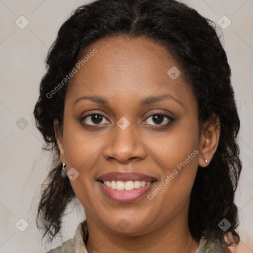 Joyful black young-adult female with long  brown hair and brown eyes