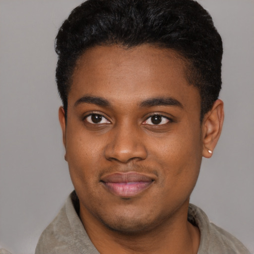 Joyful black young-adult male with short  brown hair and brown eyes