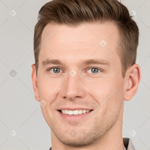 Joyful white young-adult male with short  brown hair and grey eyes