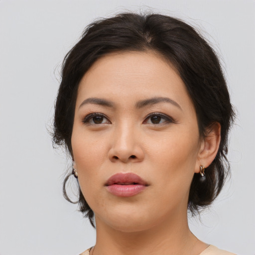 Joyful asian young-adult female with medium  brown hair and brown eyes
