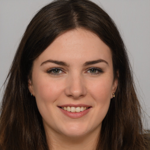 Joyful white young-adult female with long  brown hair and brown eyes