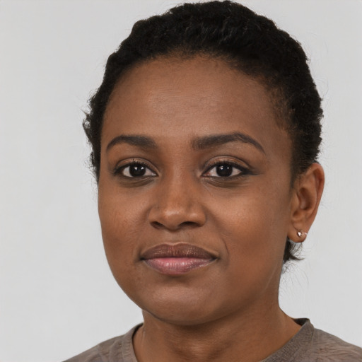 Joyful black young-adult female with short  black hair and brown eyes
