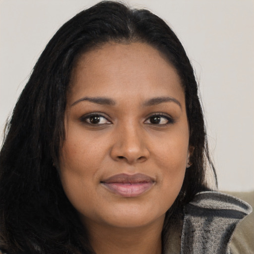 Joyful black young-adult female with long  brown hair and brown eyes