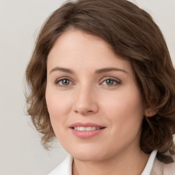 Joyful white young-adult female with medium  brown hair and green eyes