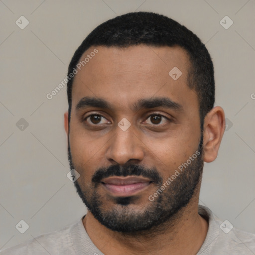 Joyful black young-adult male with short  black hair and brown eyes