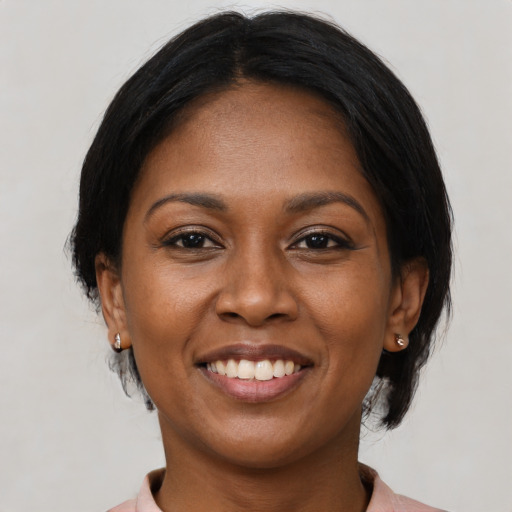 Joyful black young-adult female with medium  brown hair and brown eyes