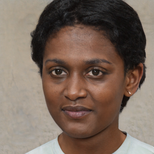 Joyful black young-adult female with short  brown hair and brown eyes