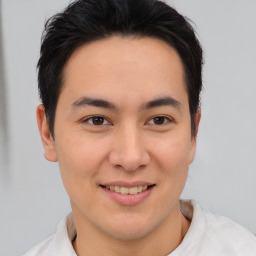 Joyful latino young-adult male with short  brown hair and brown eyes