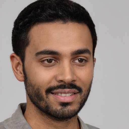 Joyful latino young-adult male with short  black hair and brown eyes