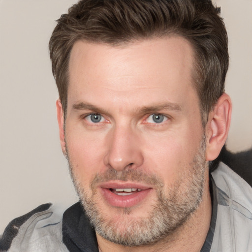 Joyful white adult male with short  brown hair and grey eyes