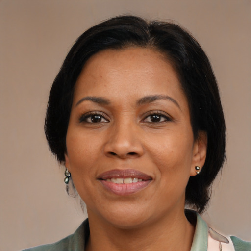 Joyful latino adult female with medium  black hair and brown eyes