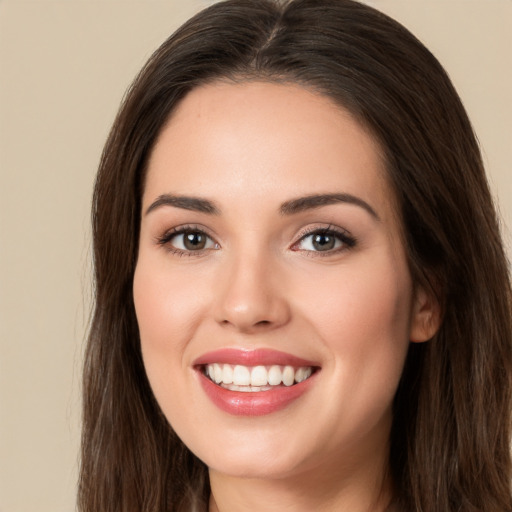 Joyful white young-adult female with long  brown hair and brown eyes