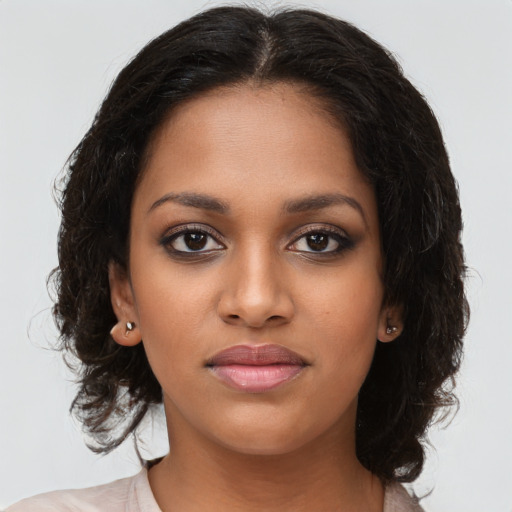 Joyful black young-adult female with long  brown hair and brown eyes