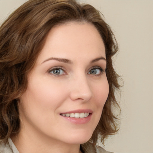 Joyful white young-adult female with medium  brown hair and green eyes