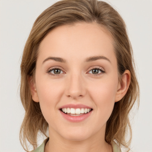 Joyful white young-adult female with medium  brown hair and green eyes