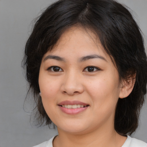 Joyful asian young-adult female with medium  brown hair and brown eyes