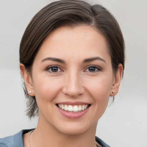 Joyful white young-adult female with medium  brown hair and grey eyes