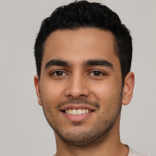 Joyful latino young-adult male with short  black hair and brown eyes