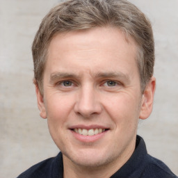 Joyful white adult male with short  brown hair and grey eyes