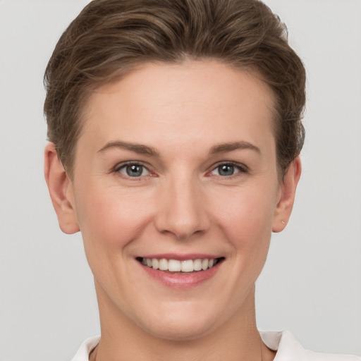 Joyful white young-adult female with short  brown hair and grey eyes