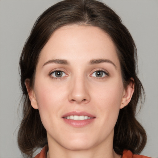 Joyful white young-adult female with medium  brown hair and green eyes