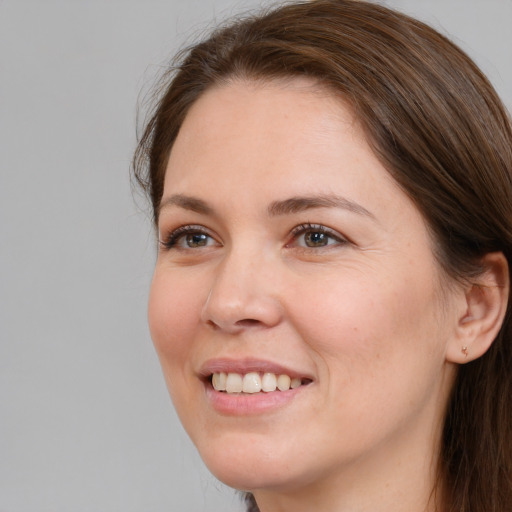 Joyful white young-adult female with long  brown hair and grey eyes