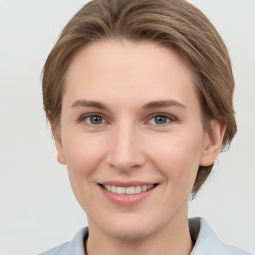 Joyful white young-adult female with short  brown hair and grey eyes