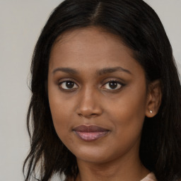 Joyful black young-adult female with long  brown hair and brown eyes