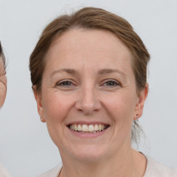 Joyful white adult female with medium  brown hair and grey eyes