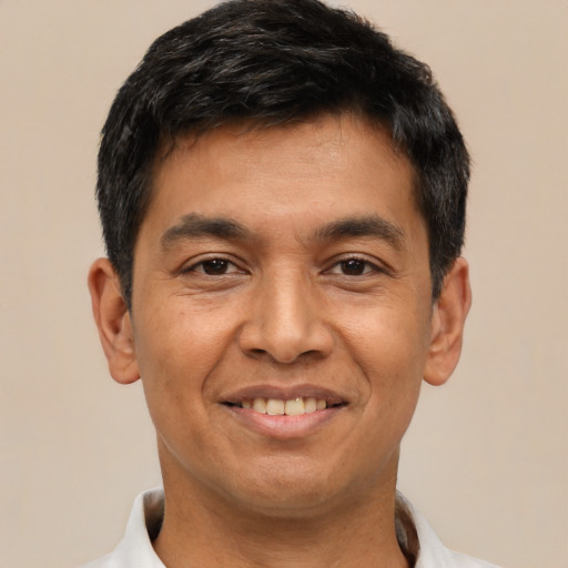 Joyful latino adult male with short  black hair and brown eyes