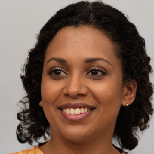 Joyful black young-adult female with medium  brown hair and brown eyes