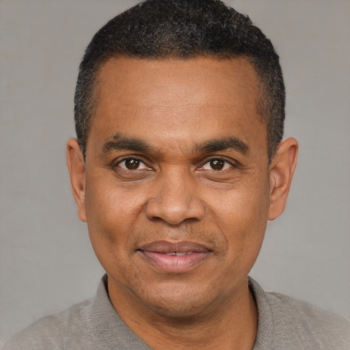 Joyful black adult male with short  black hair and brown eyes