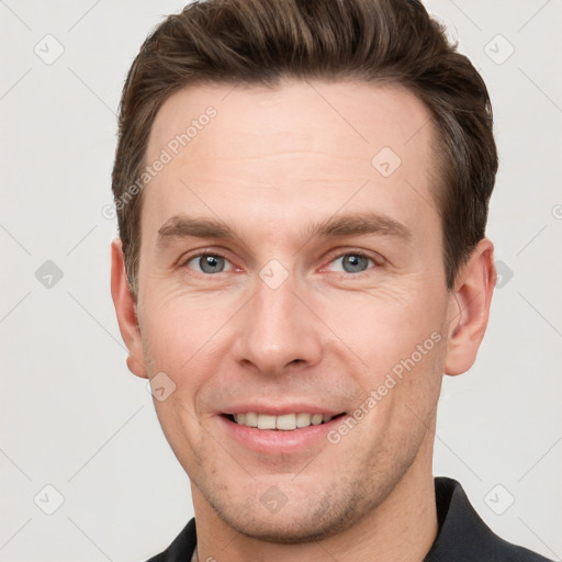 Joyful white young-adult male with short  brown hair and grey eyes