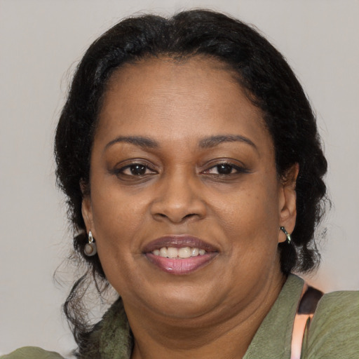 Joyful black adult female with medium  brown hair and brown eyes