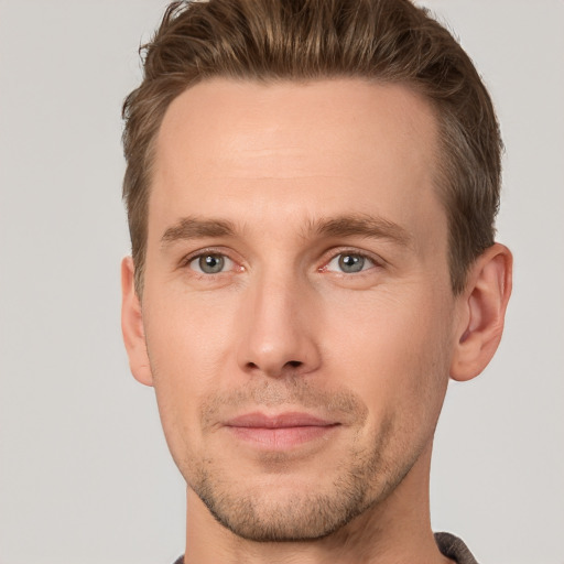 Joyful white young-adult male with short  brown hair and grey eyes