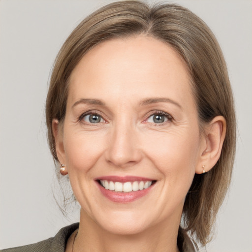 Joyful white adult female with medium  brown hair and grey eyes