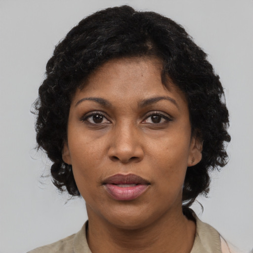 Joyful black adult female with short  black hair and brown eyes