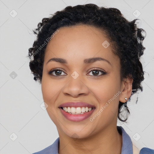 Joyful black young-adult female with long  black hair and brown eyes